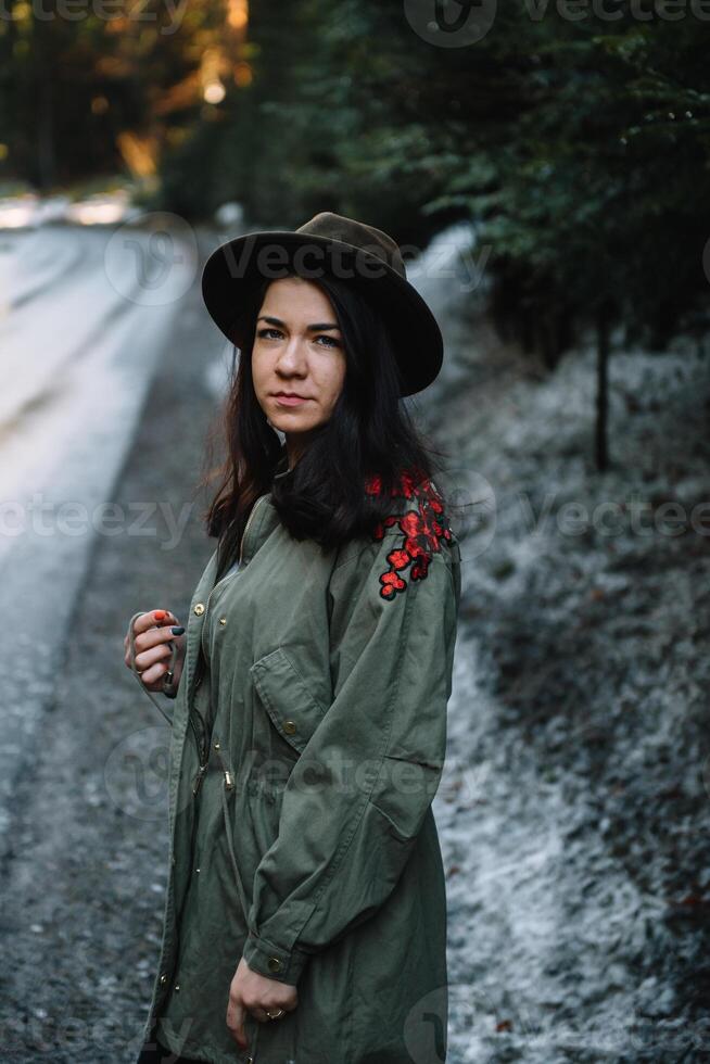 Happy girl with hat in forest at mountain road background, Relax time on holiday concept travel ,color of vintage tone and soft focus. photo