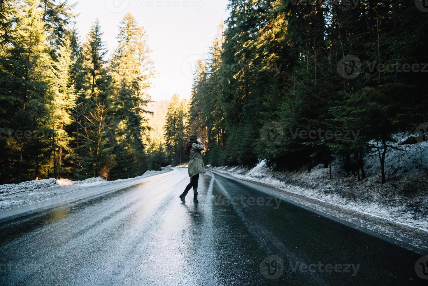 Photo from back of girl with hat in forest at mountain road. Relax time on holiday concept travel ,color of vintage tone and soft focus.