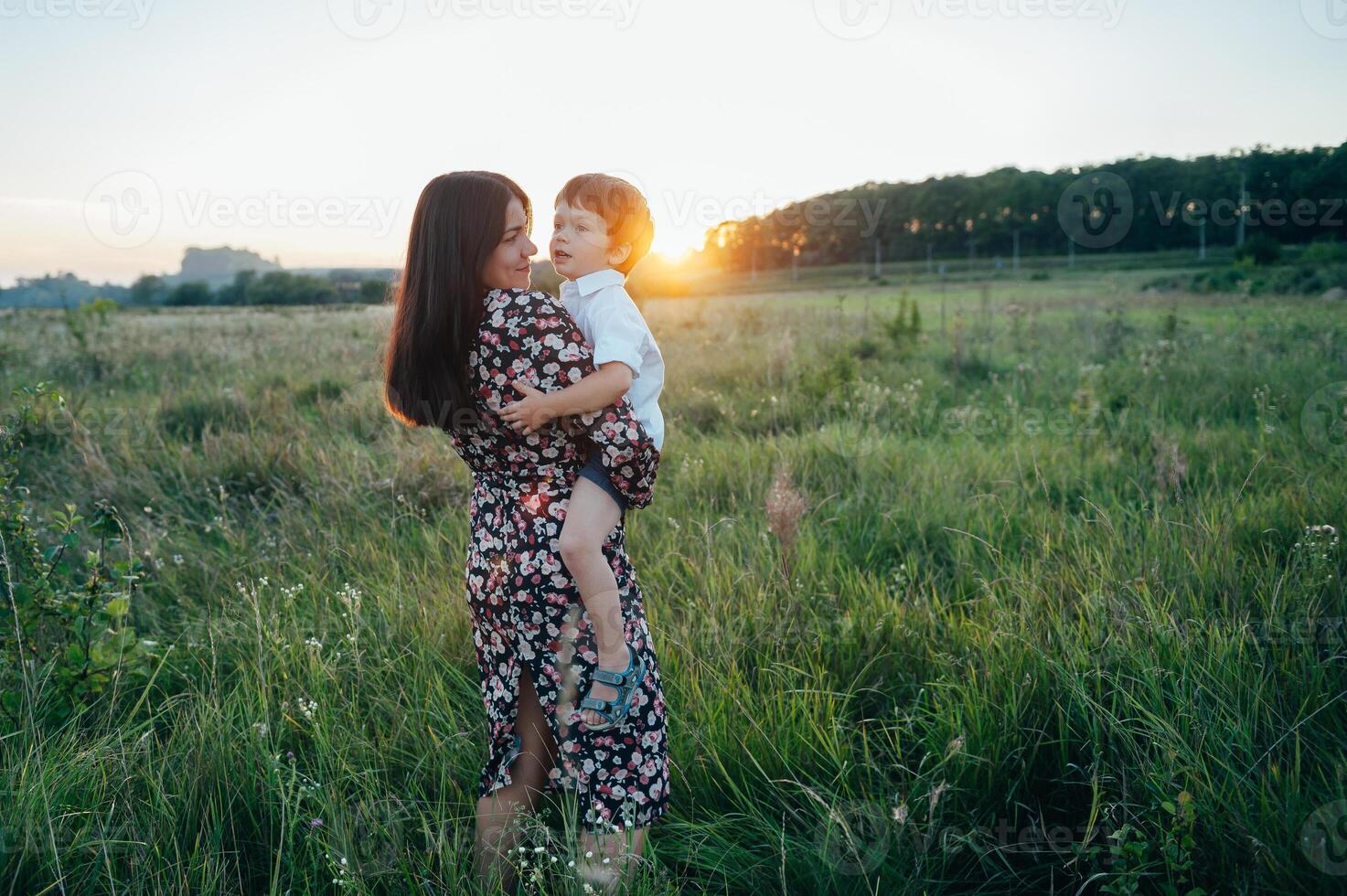 elegante madre y hermoso hijo teniendo divertido en el naturaleza. contento familia concepto. belleza naturaleza escena con familia al aire libre estilo de vida. contento familia descansando juntos. felicidad en familia vida. madres día foto