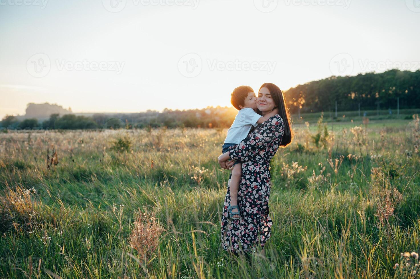 Stilish mother and handsome son having fun on the nature. Happy family concept. Beauty nature scene with family outdoor lifestyle. Happy family resting together. Happiness in family life. Mothers day photo