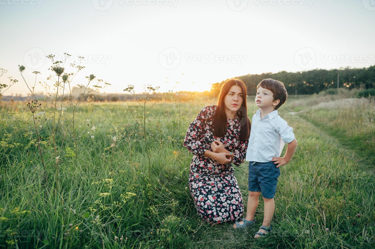 elegante madre y hermoso hijo teniendo divertido en el naturaleza. contento familia concepto. belleza naturaleza escena con familia al aire libre estilo de vida. contento familia descansando juntos. felicidad en familia vida. madres día foto