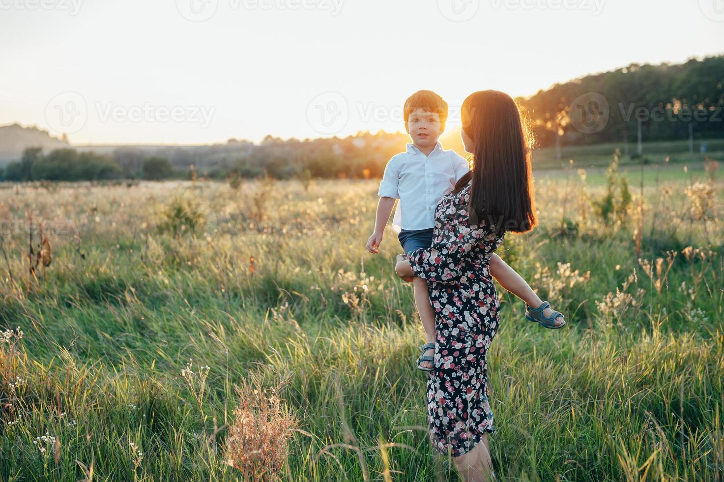 Stilish mother and handsome son having fun on the nature. Happy family concept. Beauty nature scene with family outdoor lifestyle. Happy family resting together. Happiness in family life. Mothers day photo