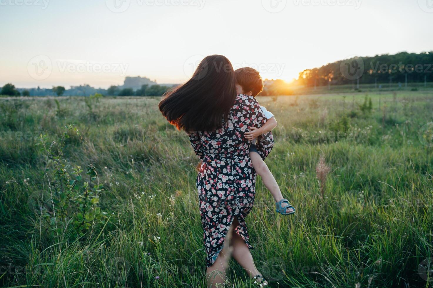 elegante madre y hermoso hijo teniendo divertido en el naturaleza. contento familia concepto. belleza naturaleza escena con familia al aire libre estilo de vida. contento familia descansando juntos. felicidad en familia vida. madres día foto