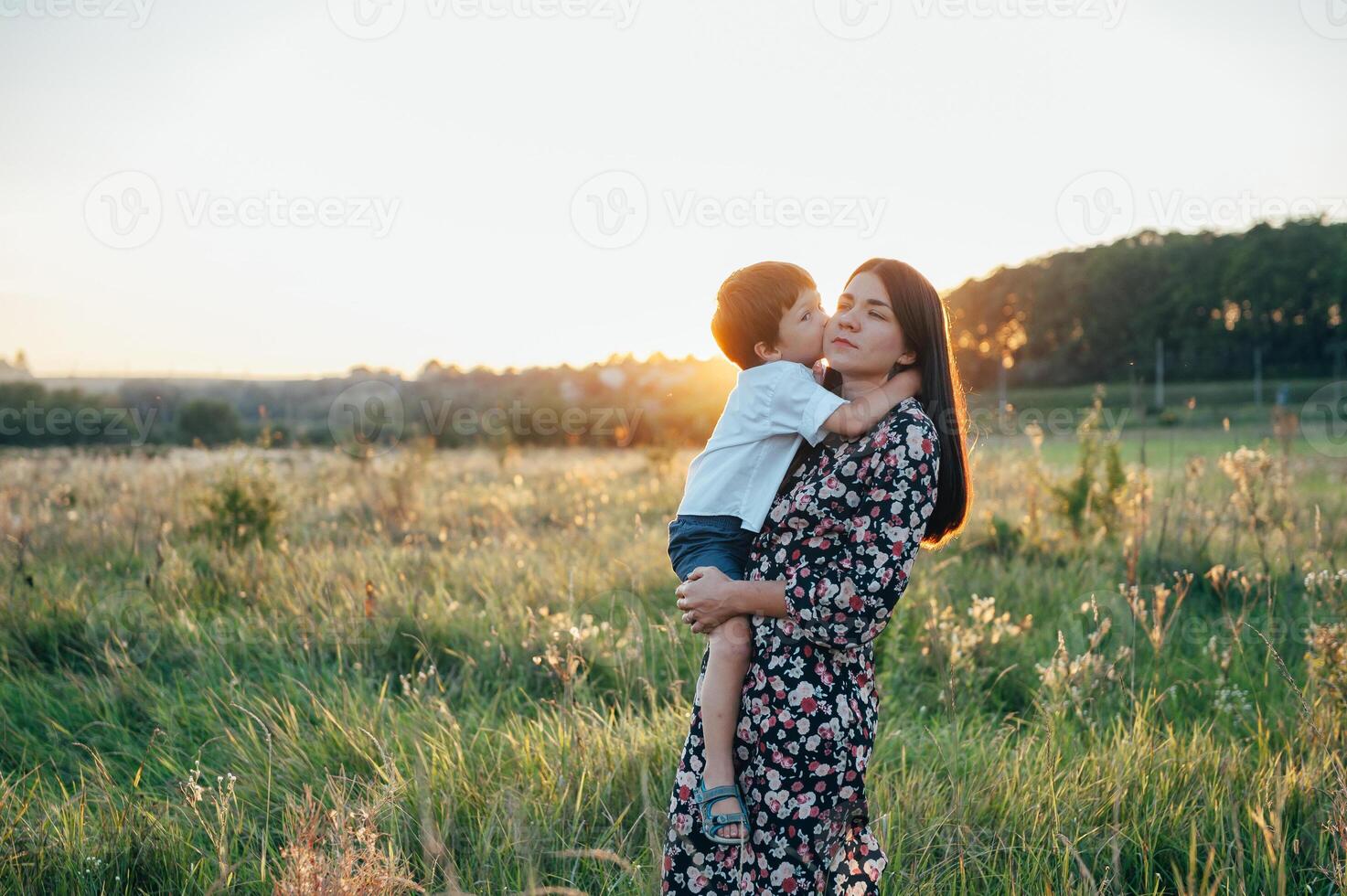 elegante madre y hermoso hijo teniendo divertido en el naturaleza. contento familia concepto. belleza naturaleza escena con familia al aire libre estilo de vida. contento familia descansando juntos. felicidad en familia vida. madres día foto