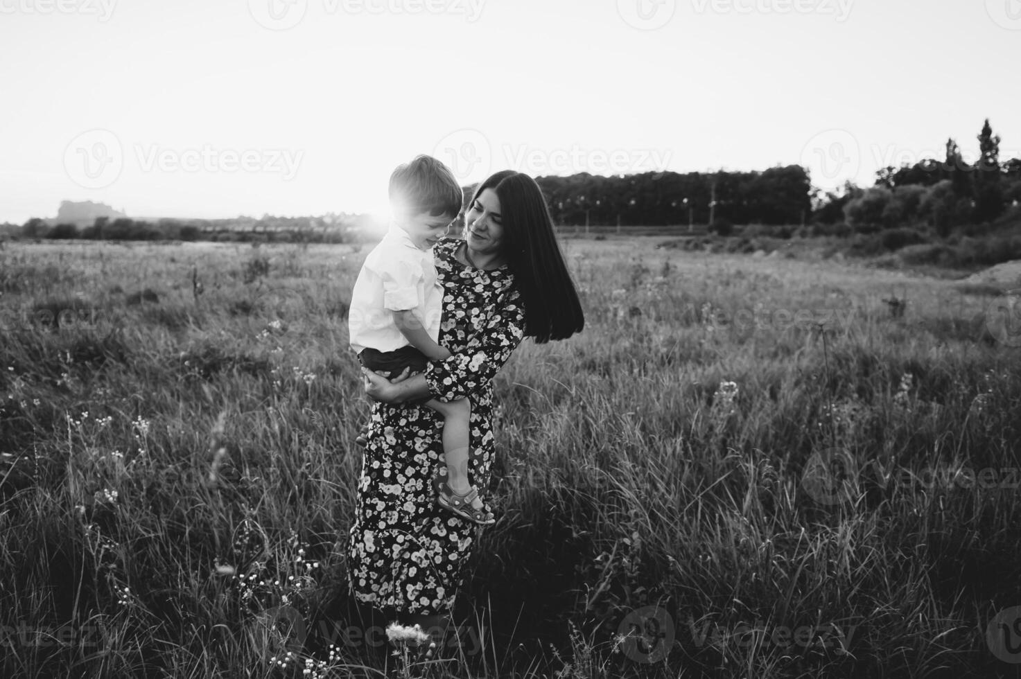 elegante madre y hermoso hijo teniendo divertido en el naturaleza. contento familia concepto. belleza naturaleza escena con familia al aire libre estilo de vida. contento familia descansando juntos. felicidad en familia vida. madres día foto