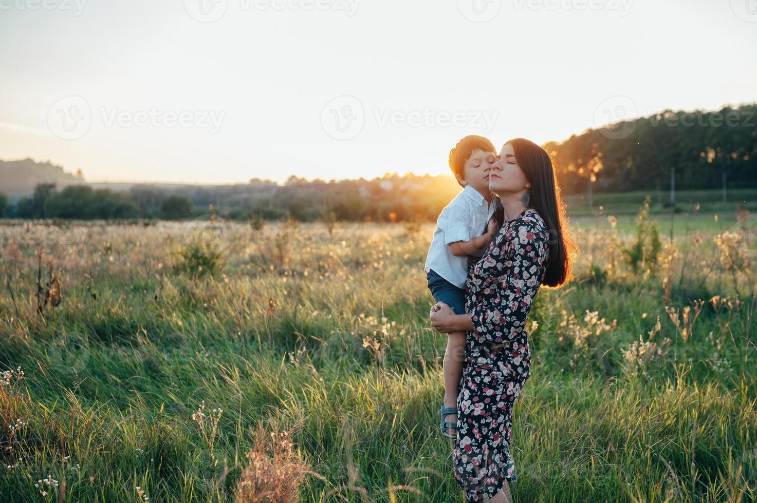 elegante madre y hermoso hijo teniendo divertido en el naturaleza. contento familia concepto. belleza naturaleza escena con familia al aire libre estilo de vida. contento familia descansando juntos. felicidad en familia vida. madres día foto