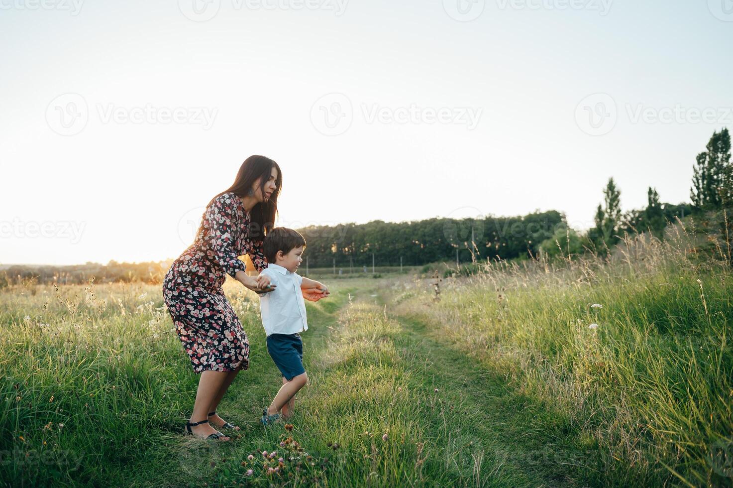 elegante madre y hermoso hijo teniendo divertido en el naturaleza. contento familia concepto. belleza naturaleza escena con familia al aire libre estilo de vida. contento familia descansando juntos. felicidad en familia vida. madres día foto