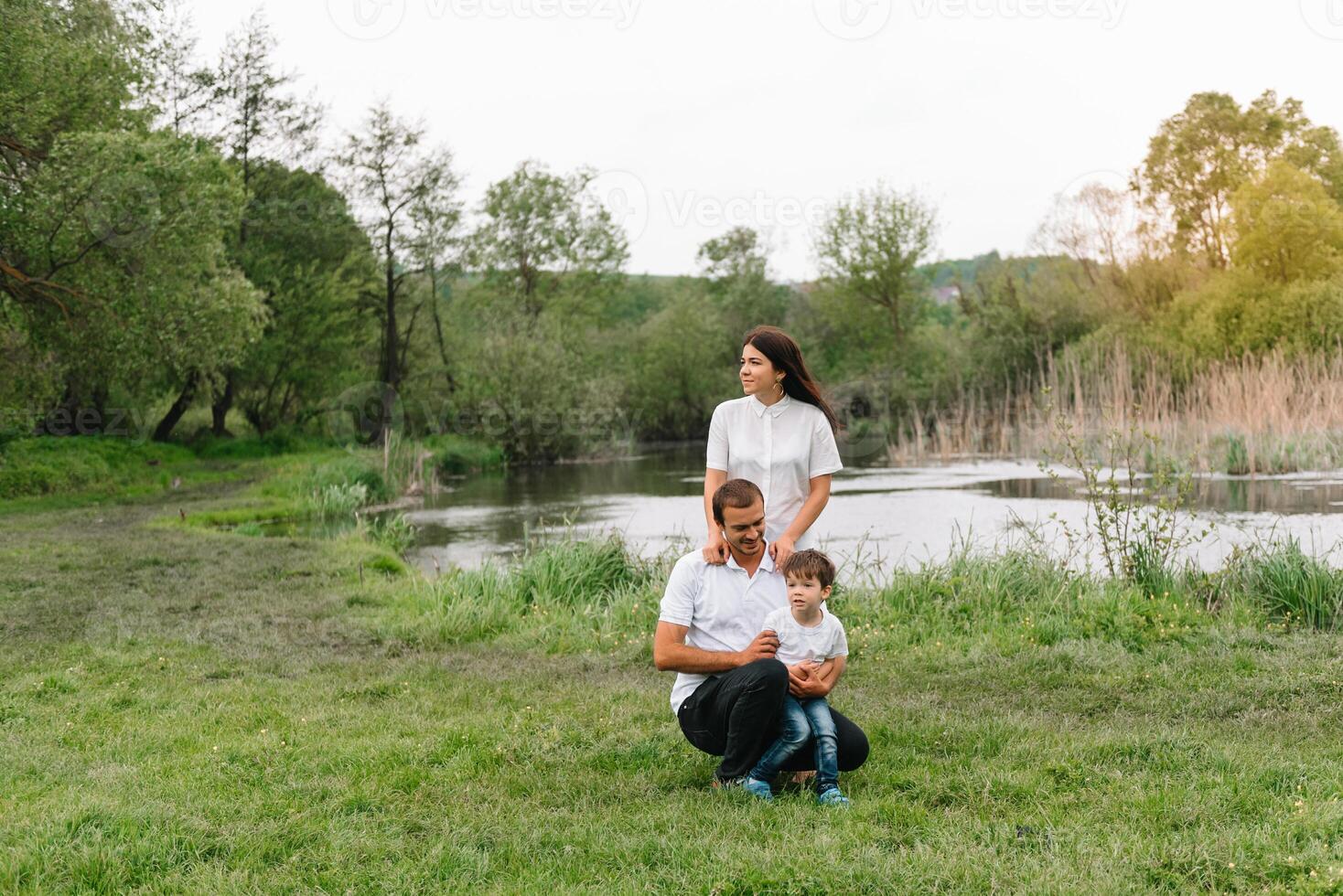 Happy family mother father and child son on nature on sunset. Mom, Dad and kid laughing and hugging, enjoying nature outside. Sunny day, good mood. concept of a happy family. photo