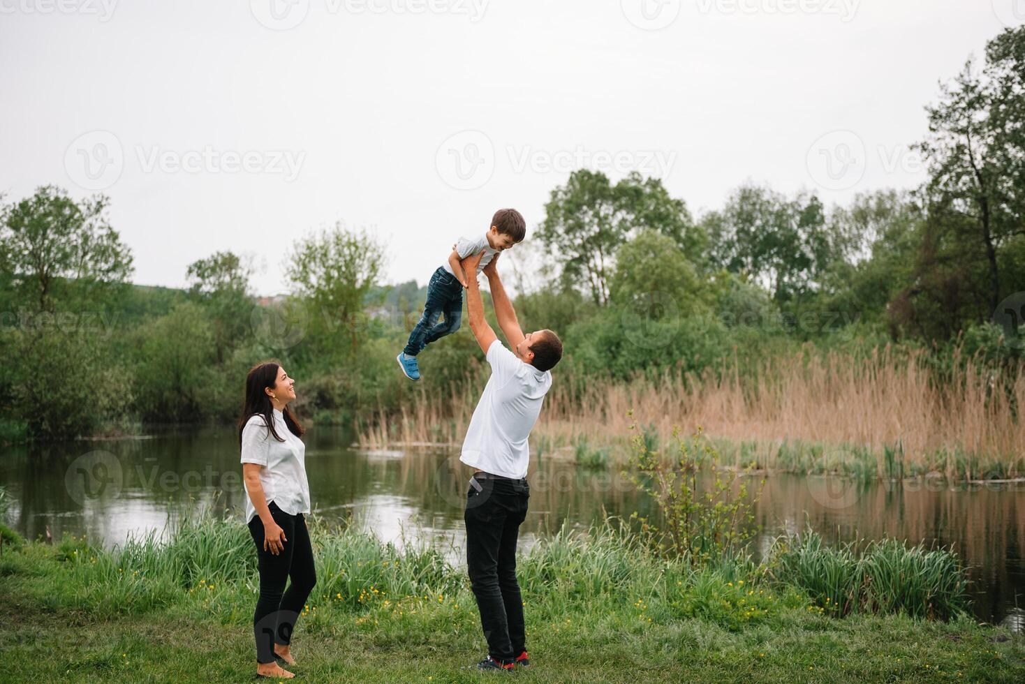 Happy family mother father and child son on nature on sunset. Mom, Dad and kid laughing and hugging, enjoying nature outside. Sunny day, good mood. concept of a happy family. photo