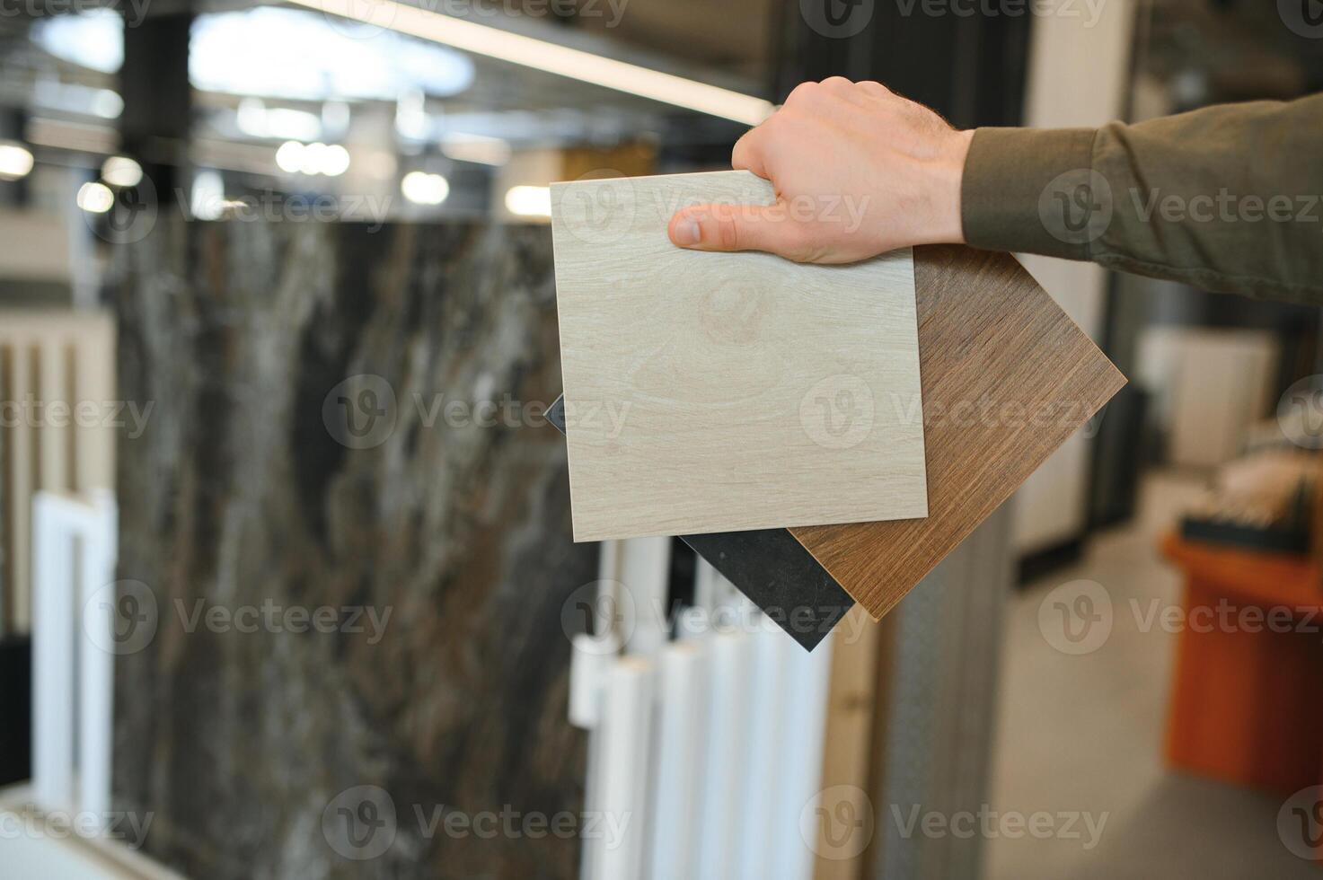 Handsome man customer choosing ceramic tile at building materials store photo