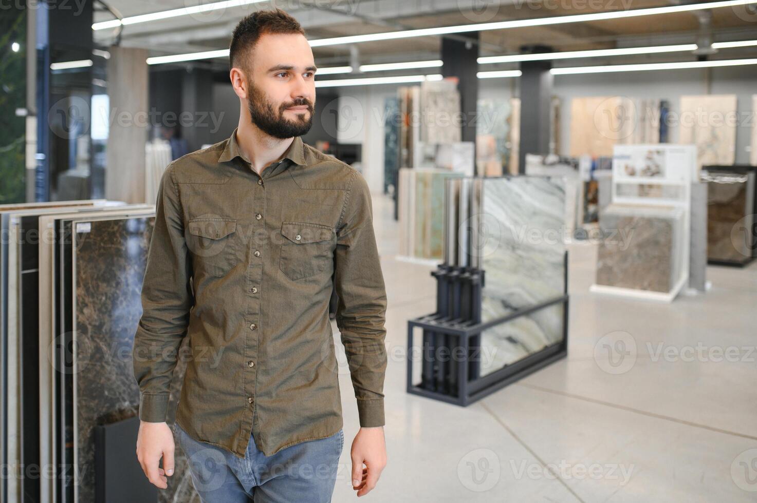 hombre elegir loseta entre diferente muestras en Tienda foto