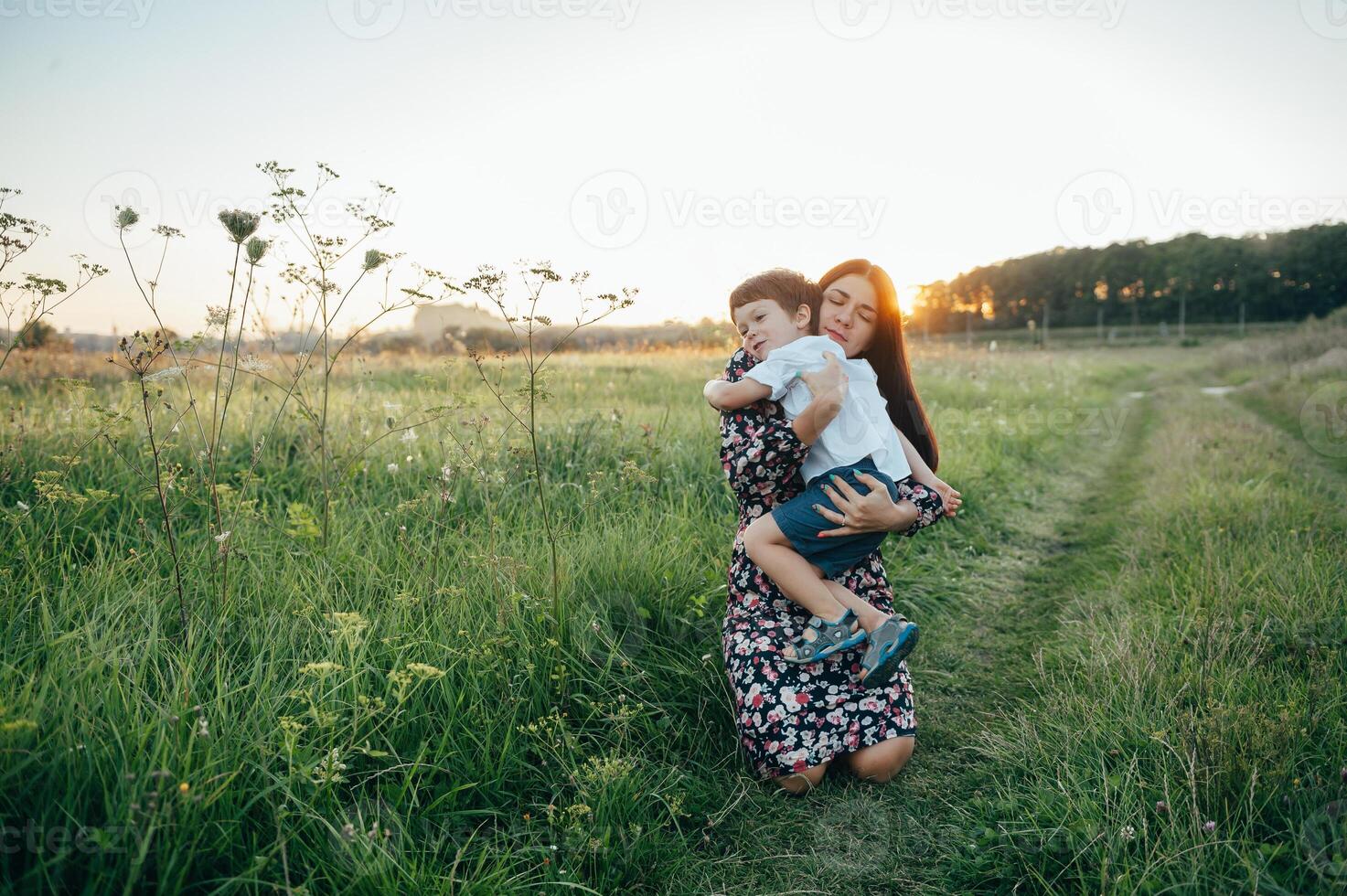 elegante madre y hermoso hijo teniendo divertido en el naturaleza. contento familia concepto. belleza naturaleza escena con familia al aire libre estilo de vida. contento familia descansando juntos. felicidad en familia vida. madres día foto