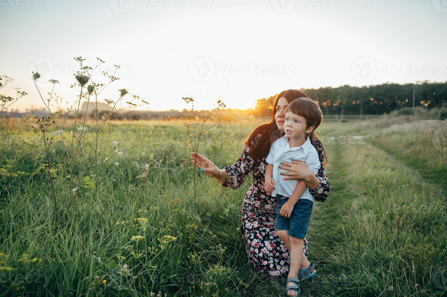 elegante madre y hermoso hijo teniendo divertido en el naturaleza. contento familia concepto. belleza naturaleza escena con familia al aire libre estilo de vida. contento familia descansando juntos. felicidad en familia vida. madres día foto