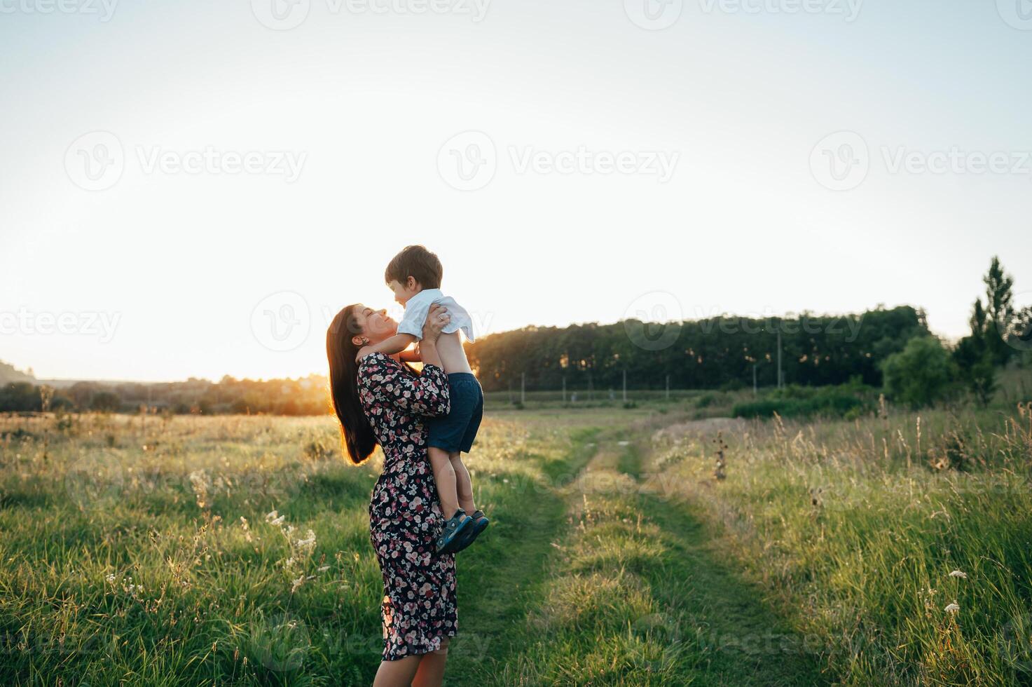 elegante madre y hermoso hijo teniendo divertido en el naturaleza. contento familia concepto. belleza naturaleza escena con familia al aire libre estilo de vida. contento familia descansando juntos. felicidad en familia vida. madres día foto