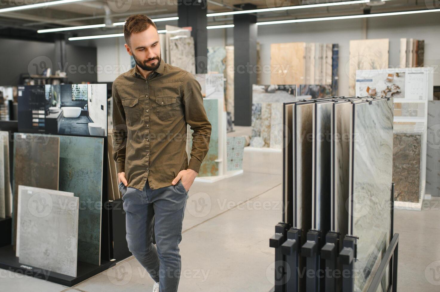 Man choosing tile among different samples in store photo
