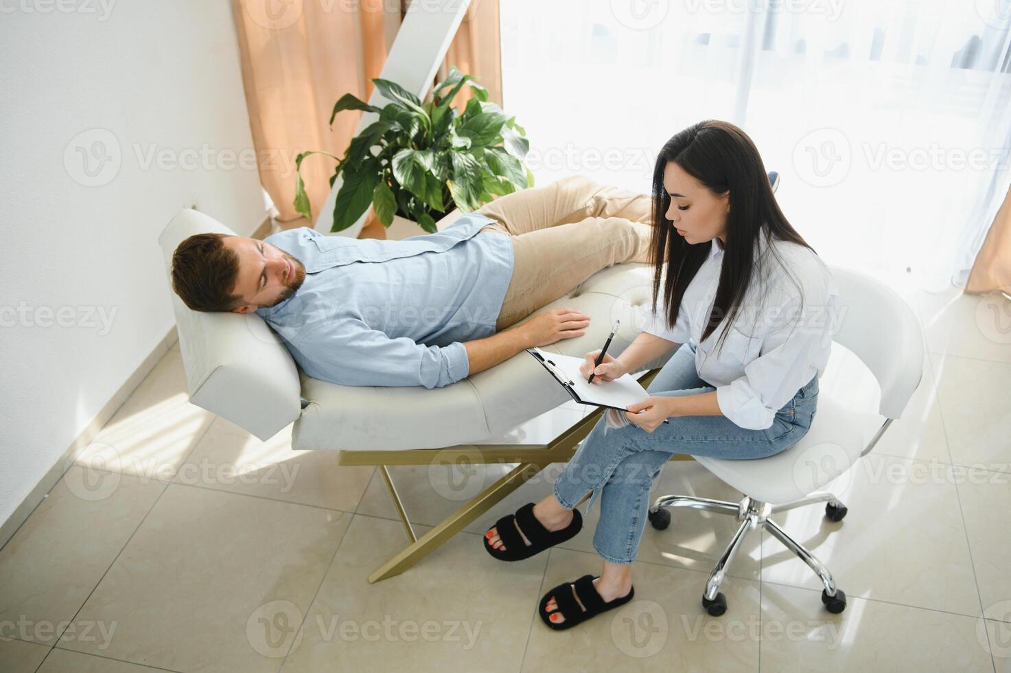 female psychologist making note while patient talking photo