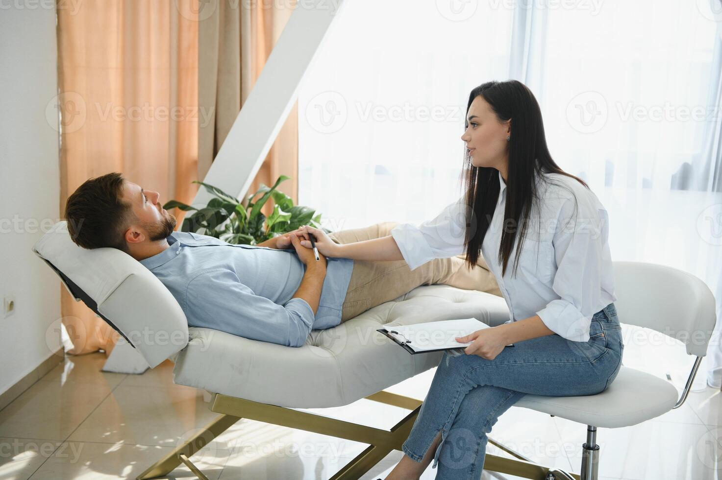 female psychologist making note while patient talking photo