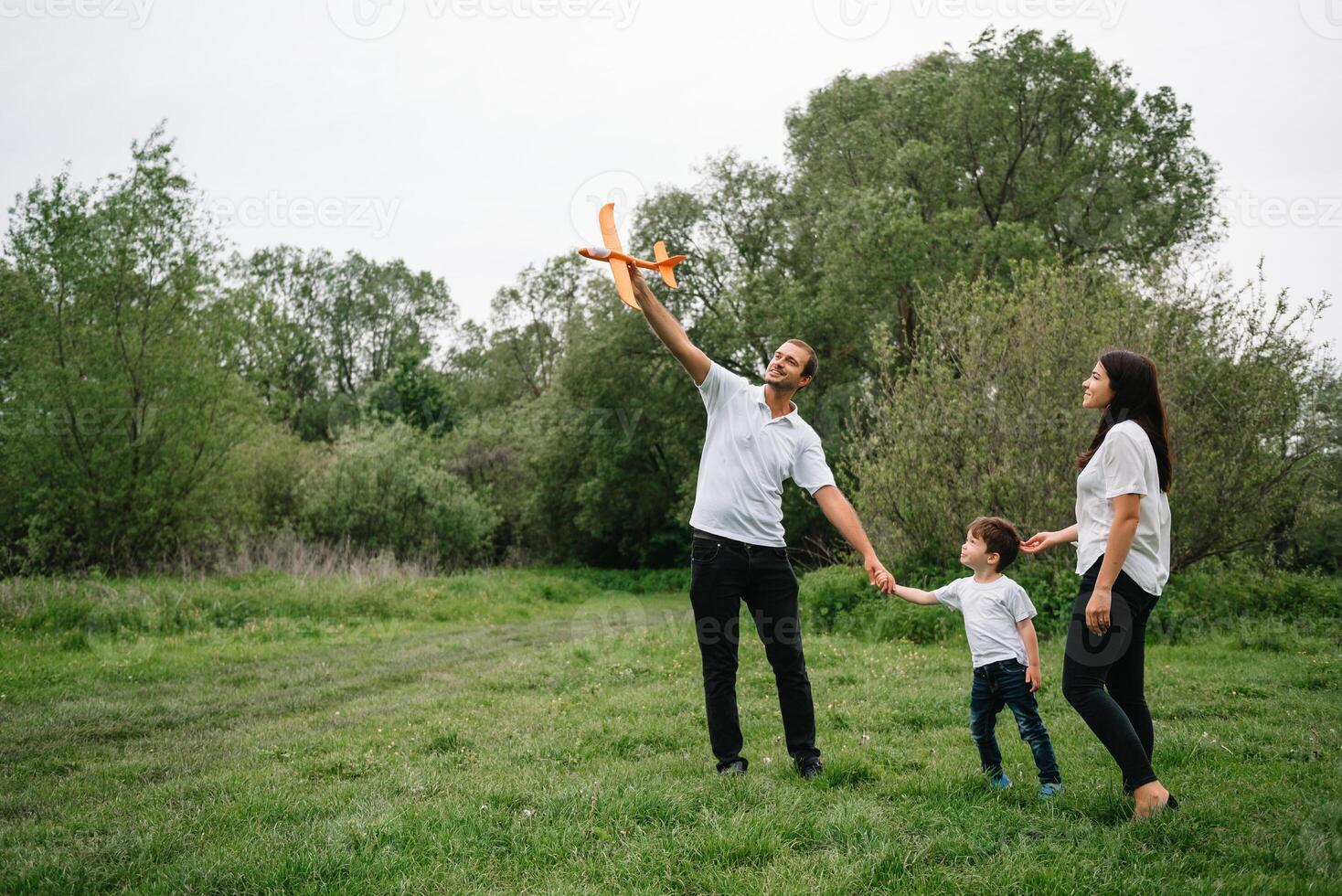 Happy family mother father and child son on nature on sunset. Mom, Dad and kid laughing and hugging, enjoying nature outside. Sunny day, good mood. concept of a happy family. photo