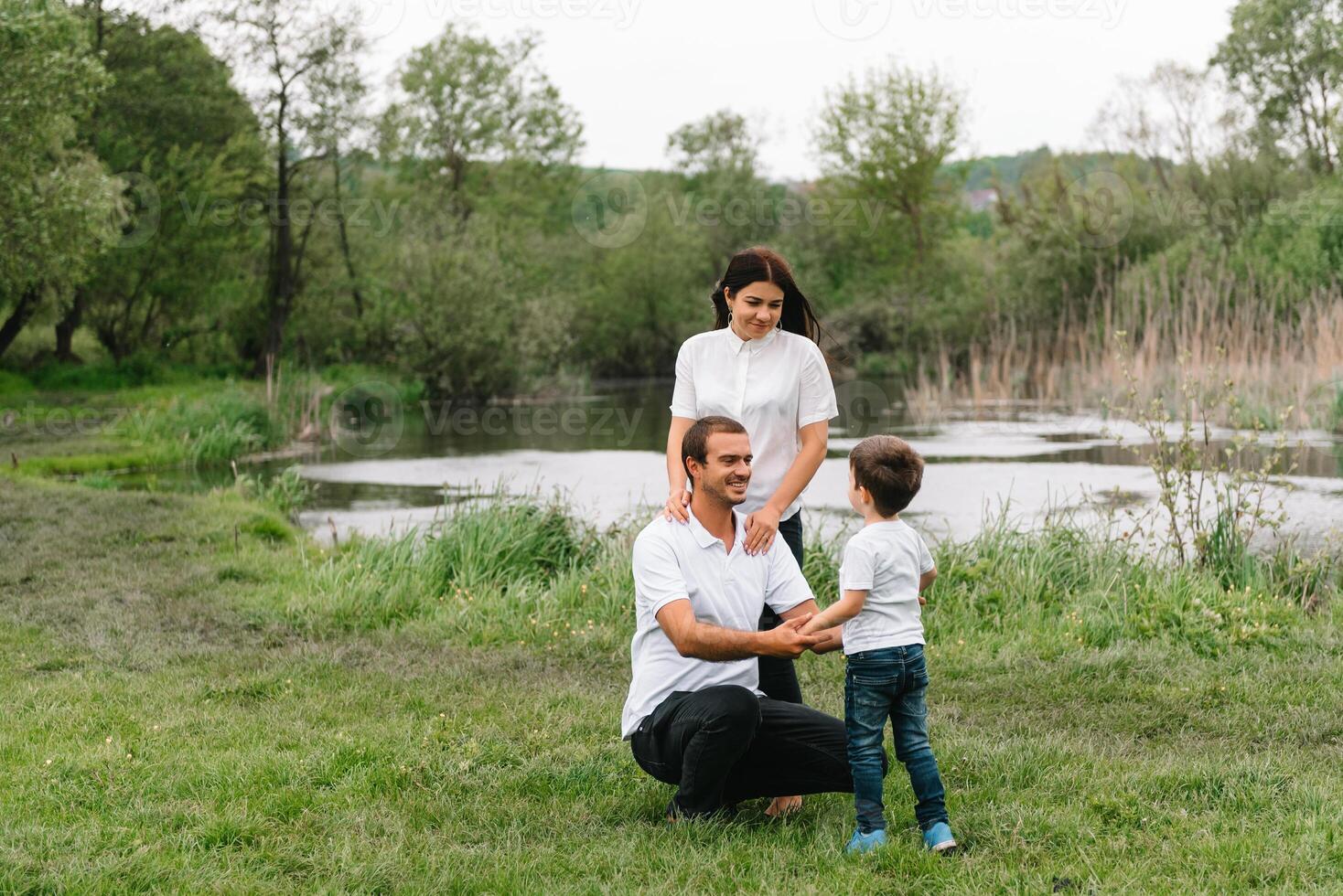 Happy family mother father and child son on nature on sunset. Mom, Dad and kid laughing and hugging, enjoying nature outside. Sunny day, good mood. concept of a happy family. photo