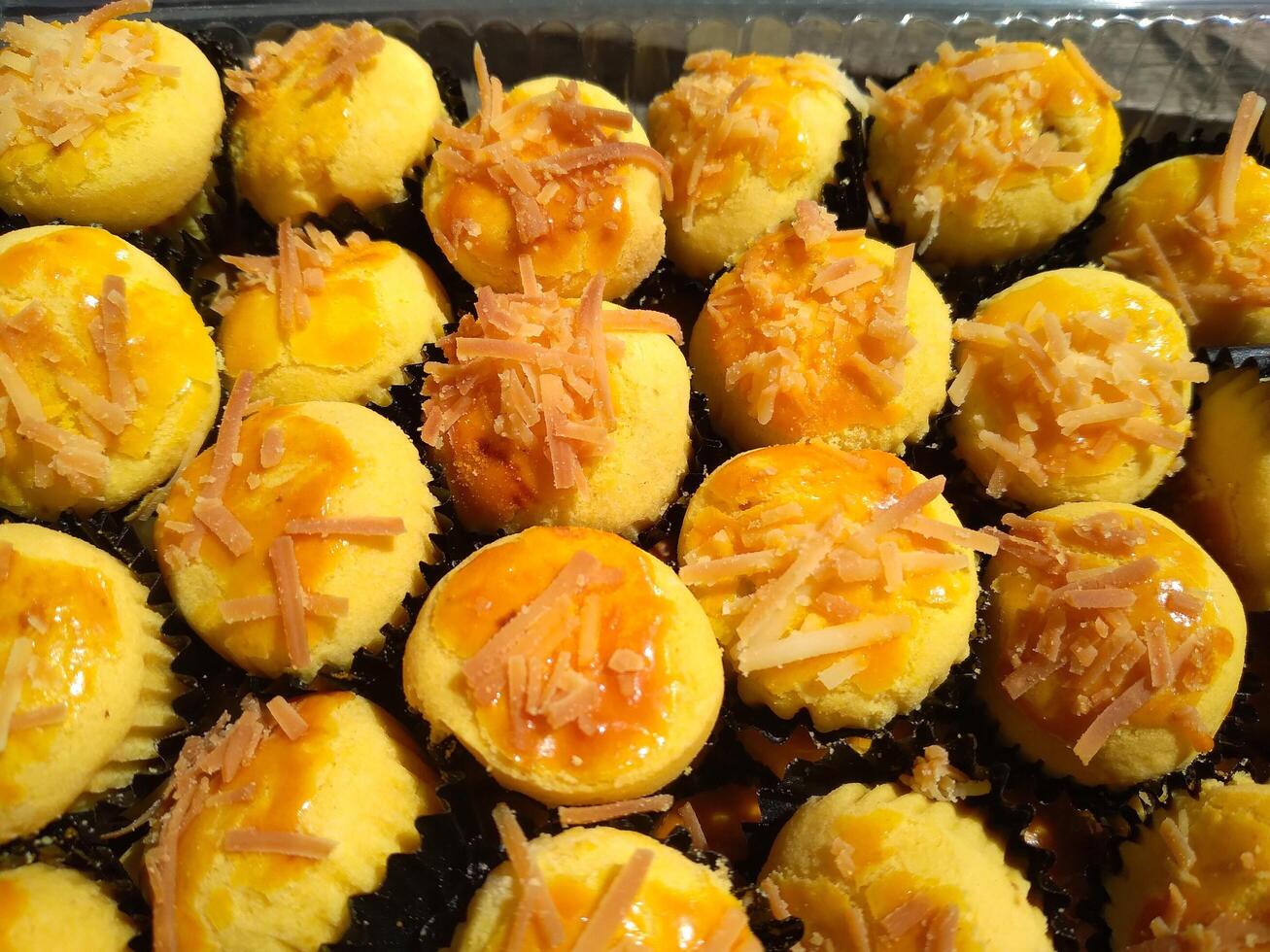 Close up of nastar cookies or pineapple tart lined up neatly on black cupcake paper. photo