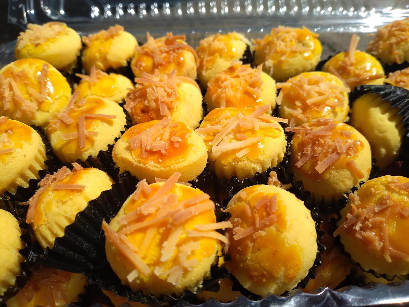 Close up of nastar cookies or pineapple tart lined up neatly on black cupcake paper. photo