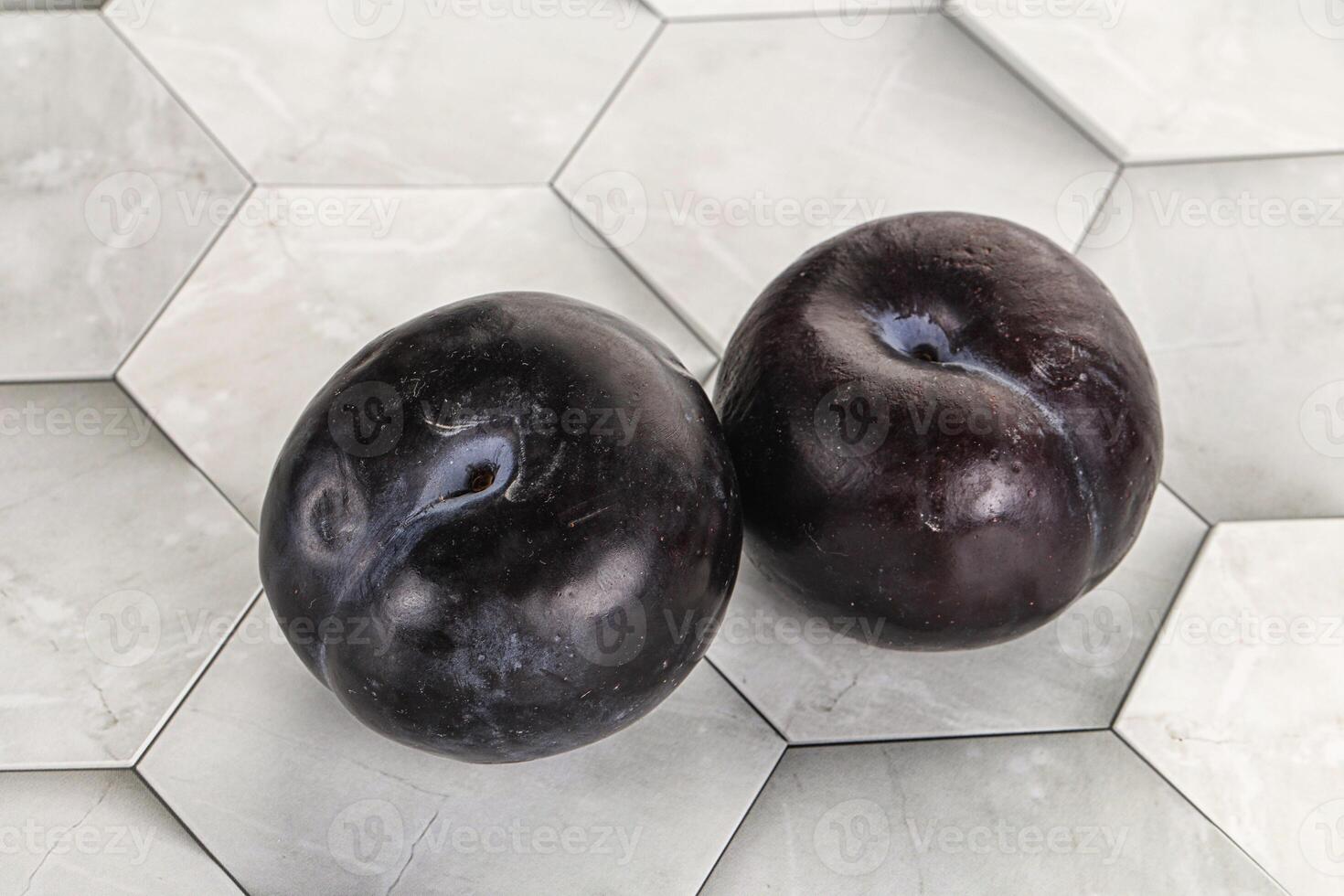 Two ripe sweet black plums photo