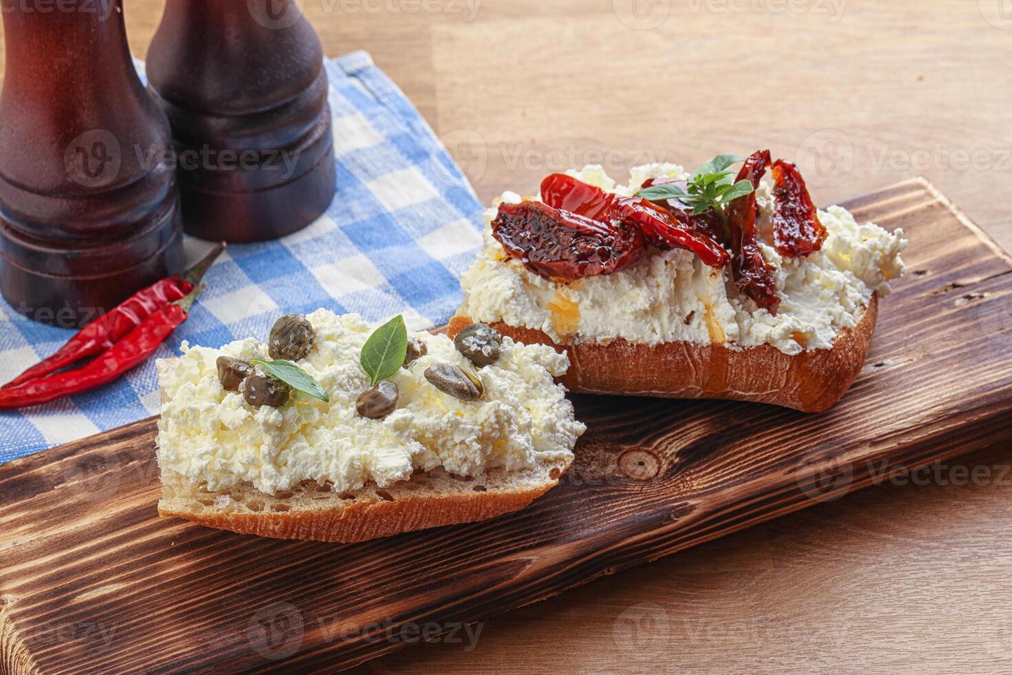 bruschetta with soft cheese capers and tomato photo