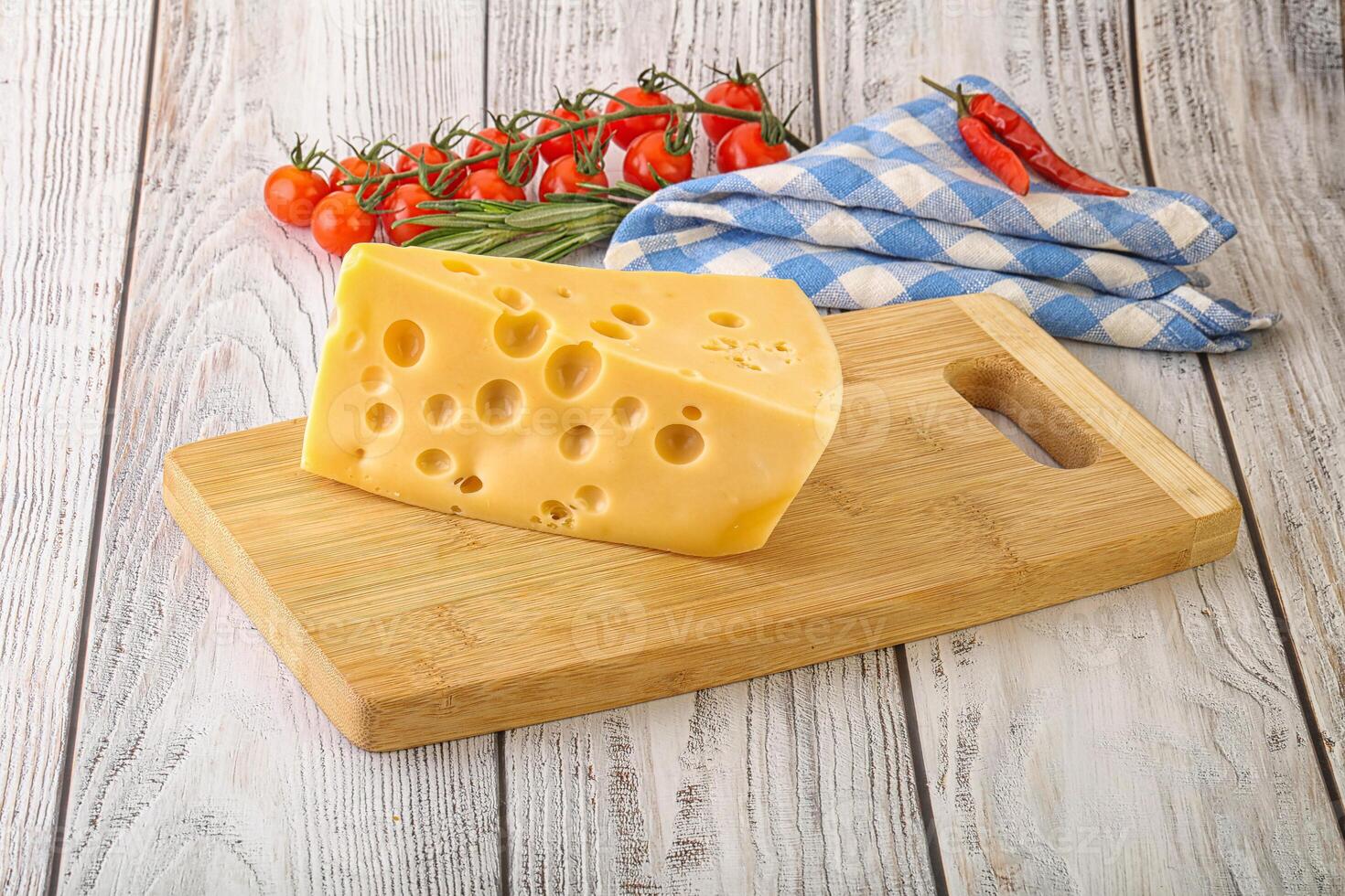 Maasdam cheese piece over board photo