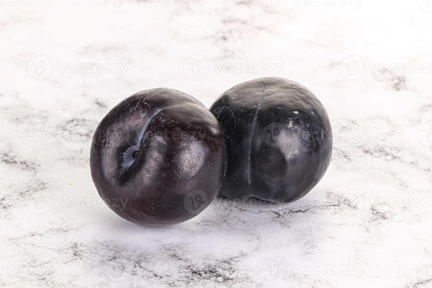 Two ripe sweet black plums photo