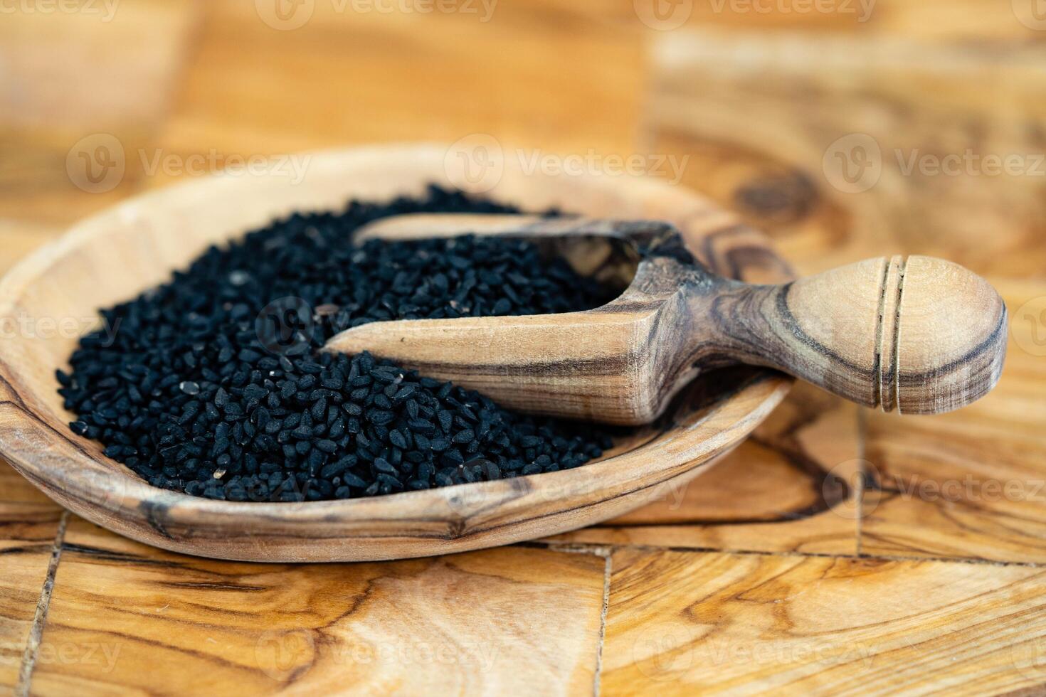 the roman coriander nigella sativa on olive wood photo