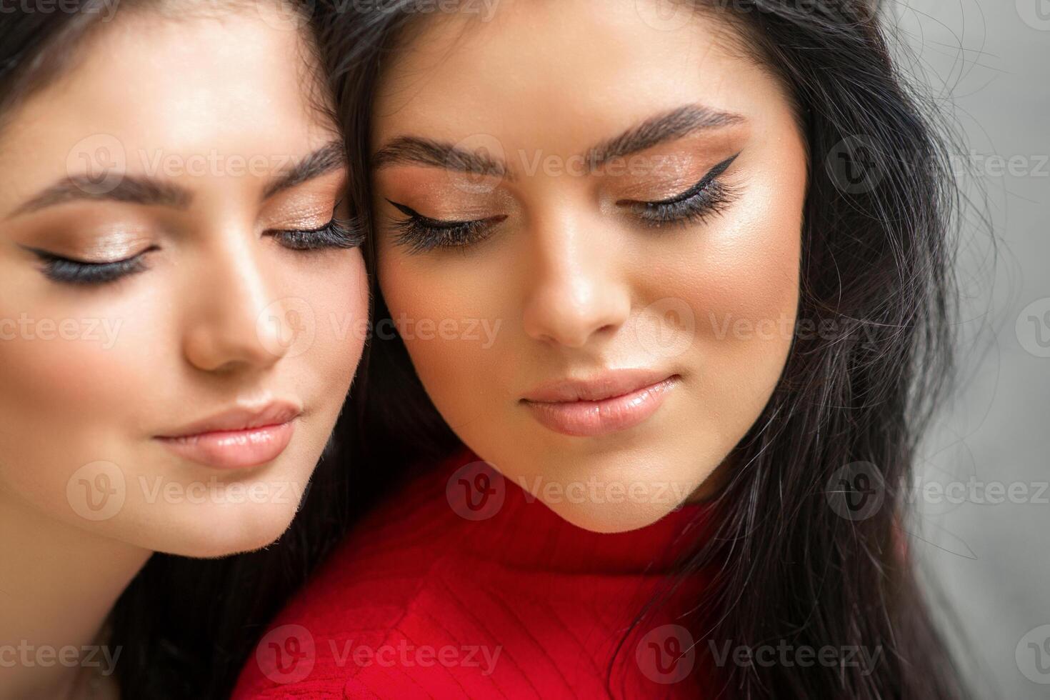Portrait of young beautiful two women with long lashes and closed eyes after eyelash extensions. photo