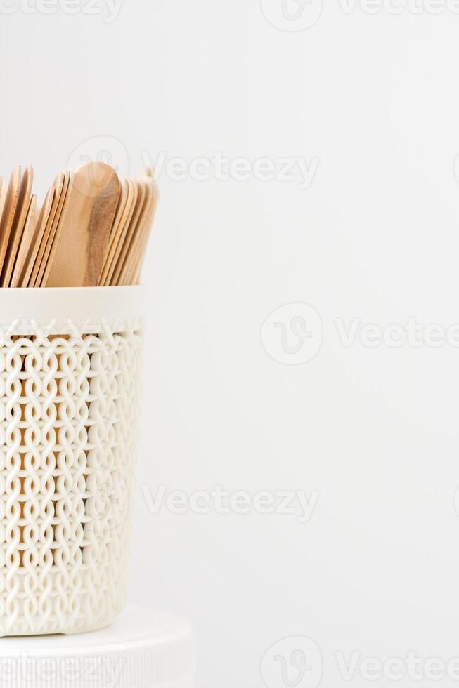 Sticks of wood for wax in white basket isolated on white background with copy space. photo