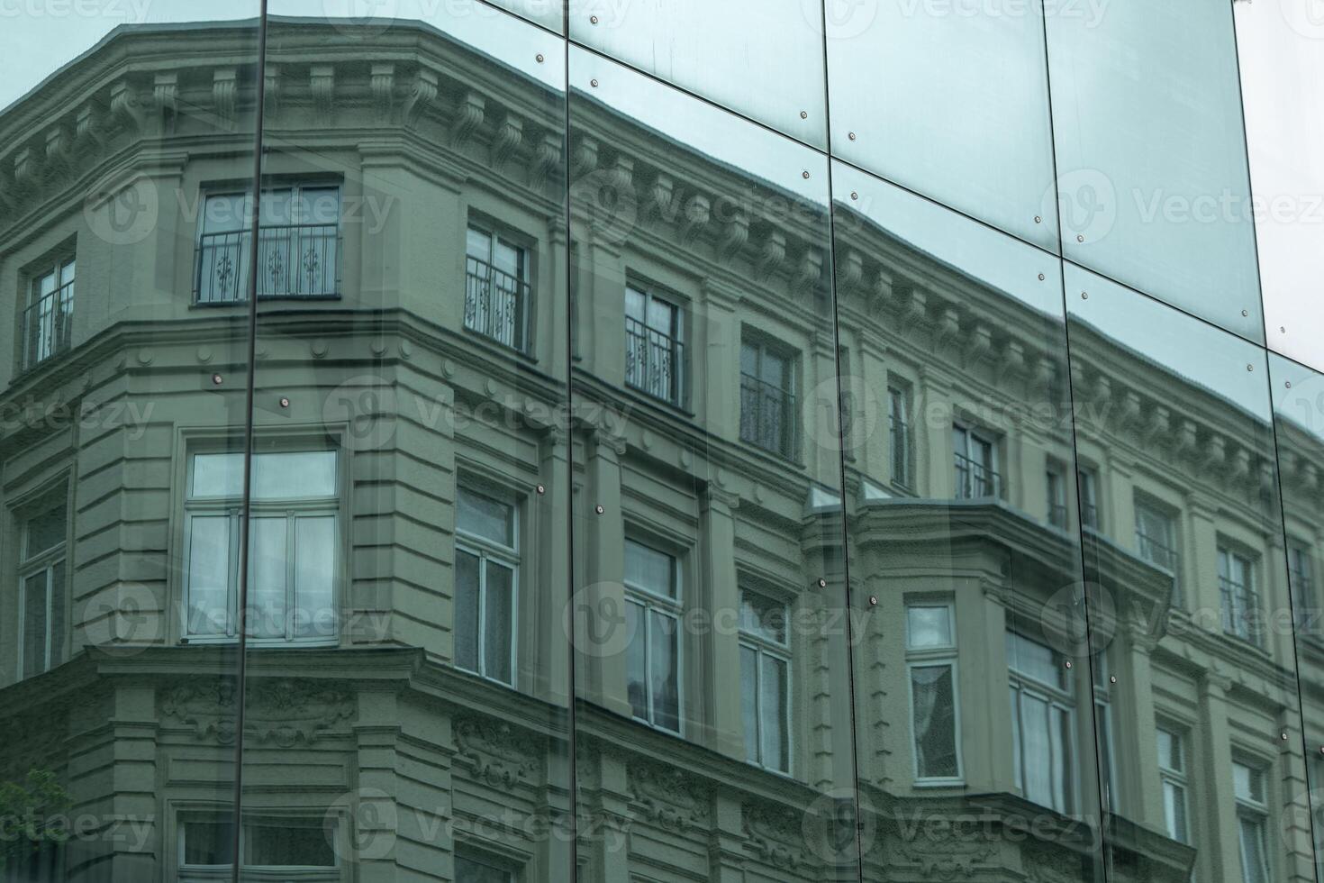 a house is reflected on a window of an exterior facade photo