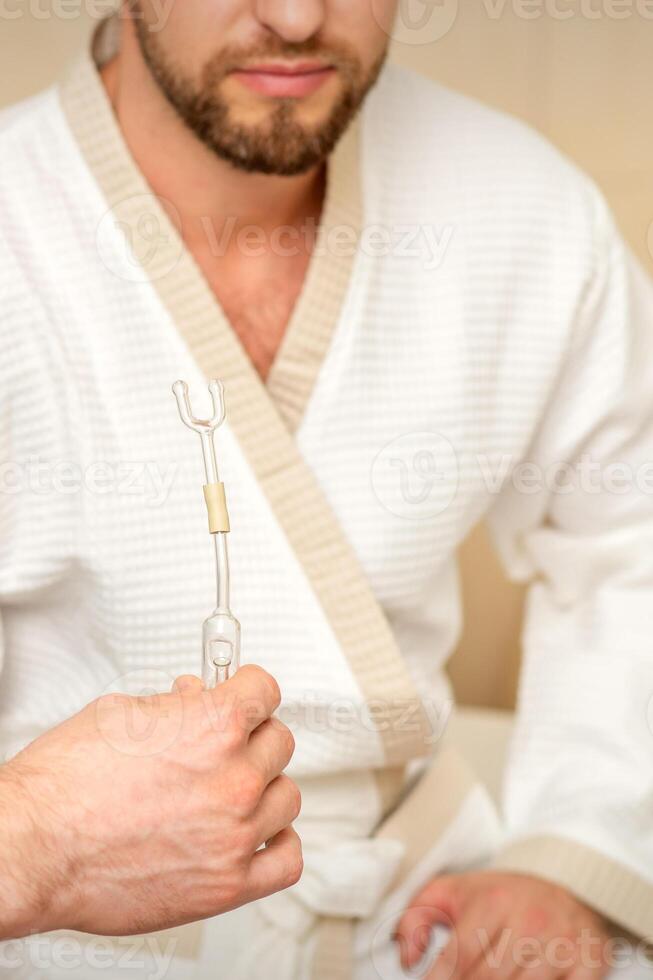 Doctor giving nasal inhalator with essential oil Maholda to a male patient in spa. photo