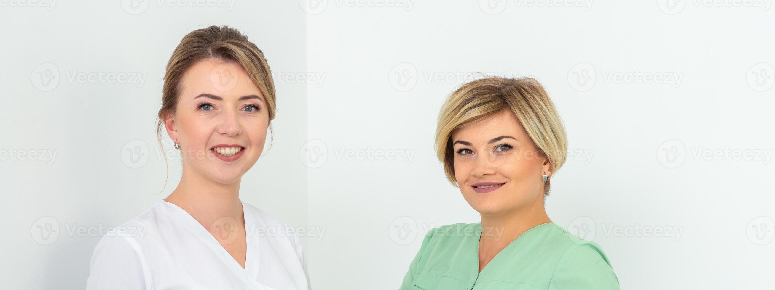 Portrait of two cosmeticians smiling against a white background. Copy space. photo
