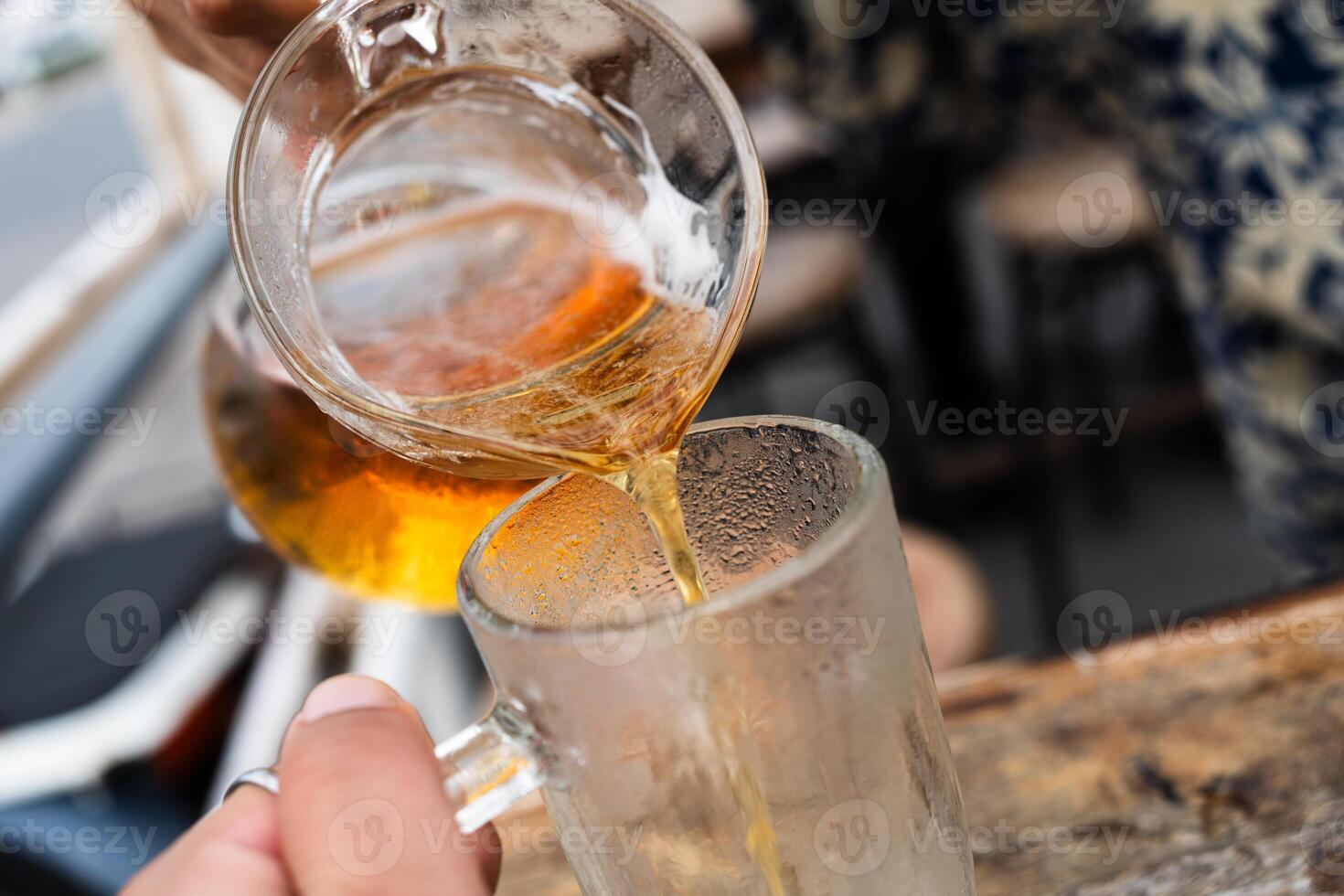 Hand of bartender pouring beer to glass photo