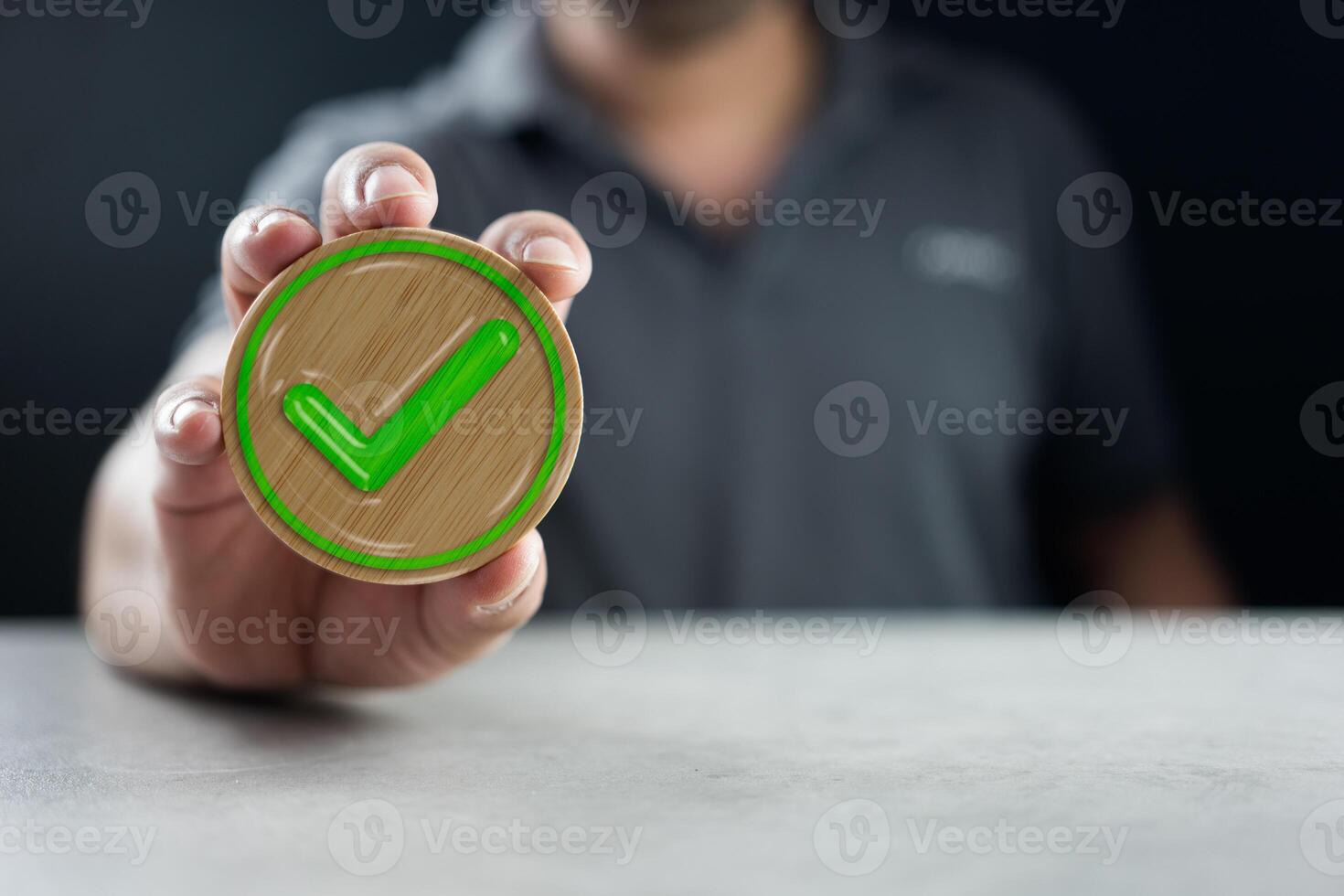 Man shows a wooden circle block with a check mark icon. Vote and choose correct photo