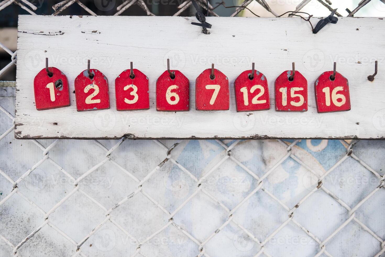 A wood red number tag for queue for motorcycle taxi drivers. Numbers for the queue photo