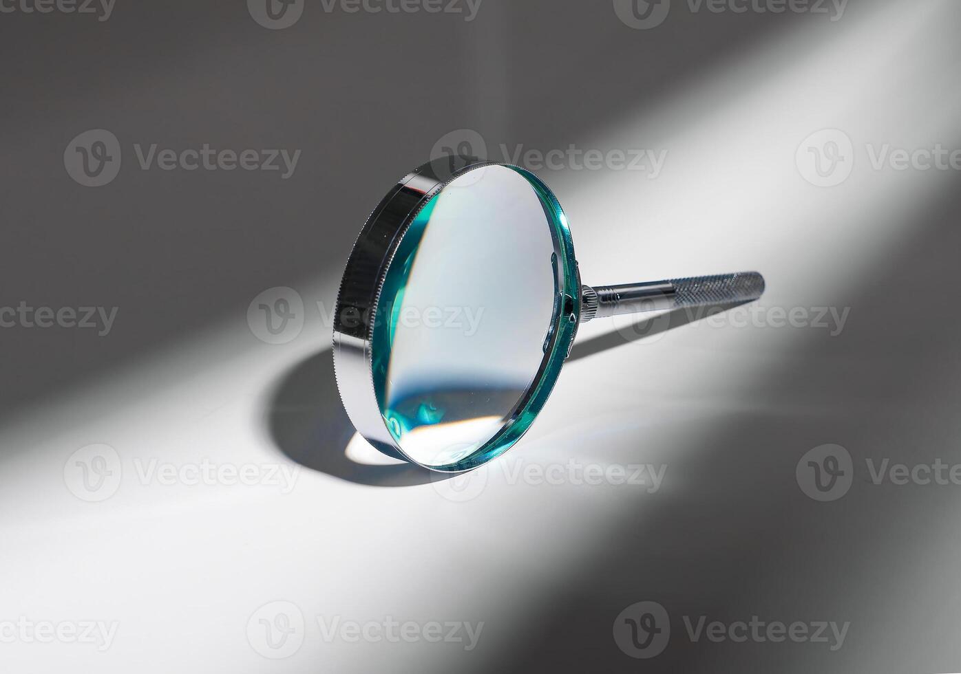 Abstract concept of investigation and discovery. Shadow and light play on silver glass, magnifying photo