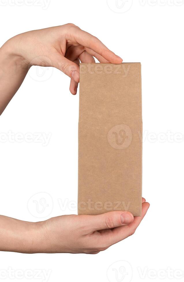 A hand holding a brown kraft cardboard box photo