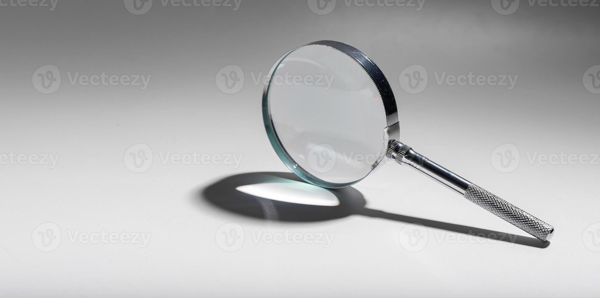 Silver glass magnifier, search concept. Magnify object clue, handle analyze, magnification. photo
