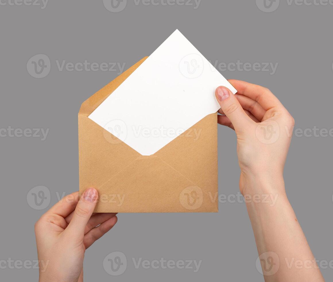 Holding open envelope with white blank card inside, postcard mockup photo