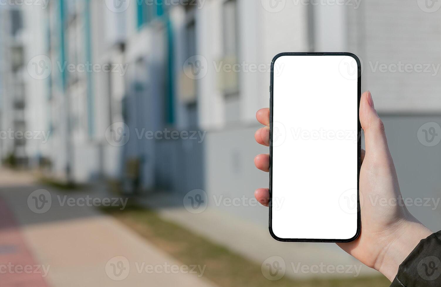 Hand holding mobile phone screen mockup, empty blank smartphone display, blurred building photo