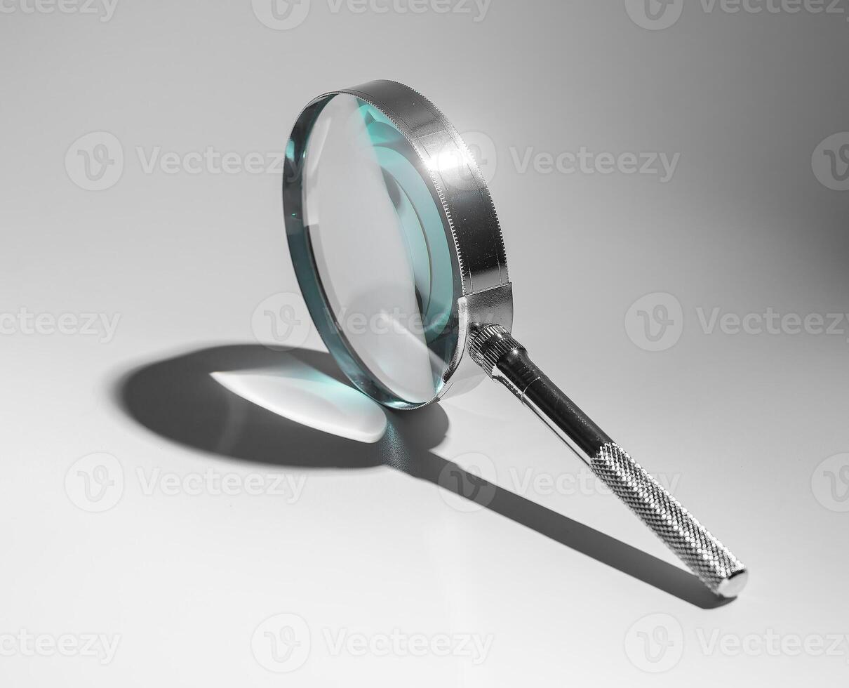 Abstract concept of scientific investigation. Silver metal handle, glass lens magnifying object. photo