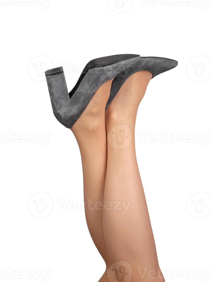 Female legs raised up, crossed feet wearing gray heeled shoes isolated on white photo