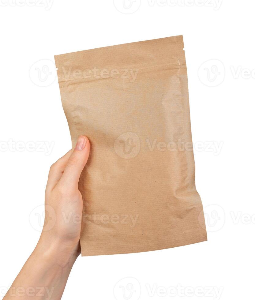 A hand holding a brown paper bag photo