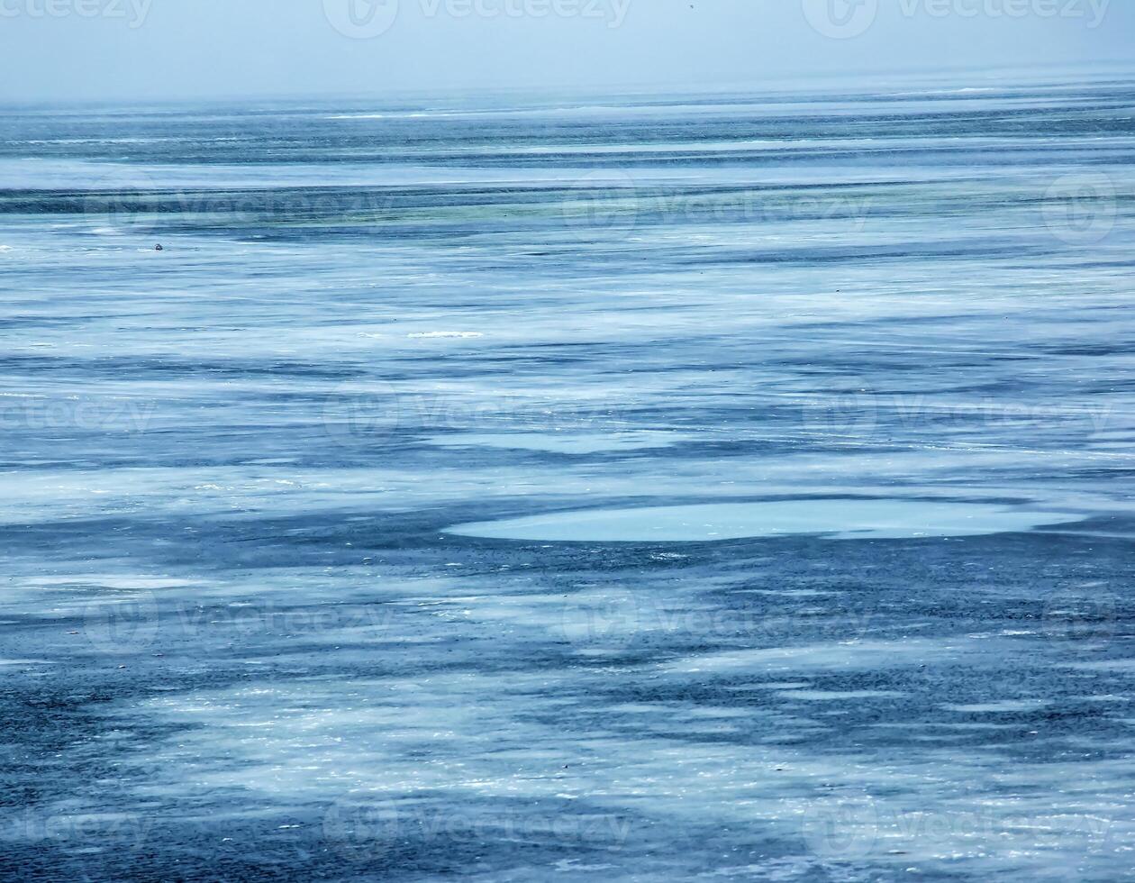 Ice surface of the river. Texture of ice shards and water. Winter background photo