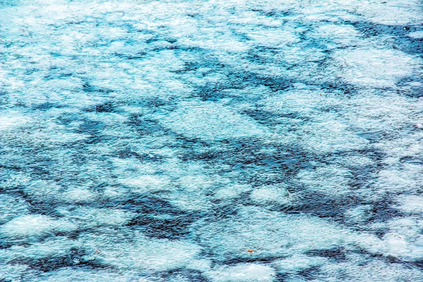 Ice surface of the river. Texture of ice shards and water. Winter background photo