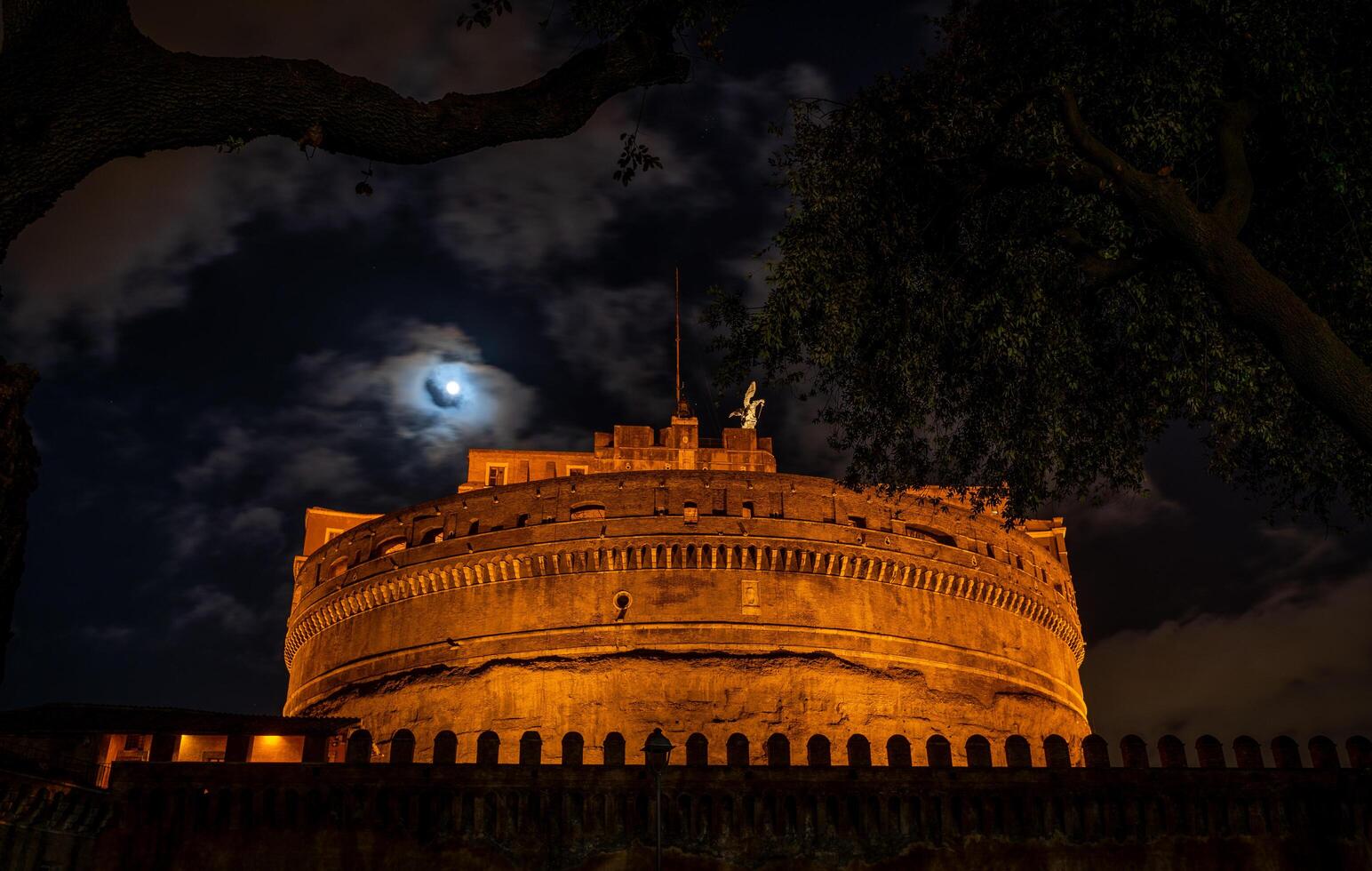 noche ver mediante el ramas de un árbol de el castel sant'angelo fortaleza foto