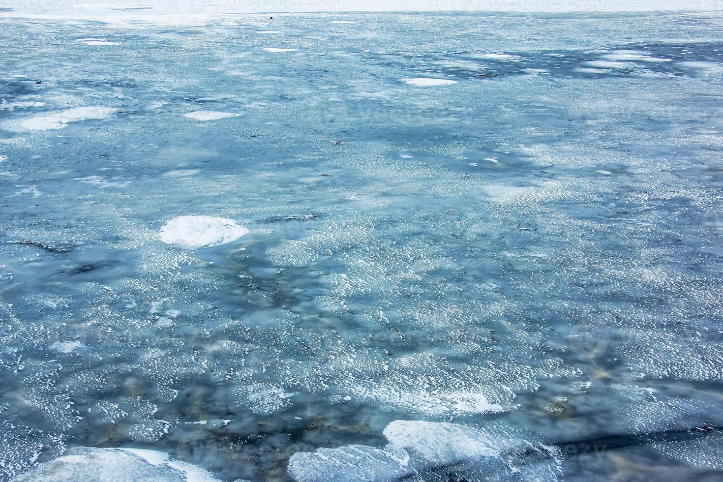 Ice surface of the river. Texture of ice shards and water. Winter background photo